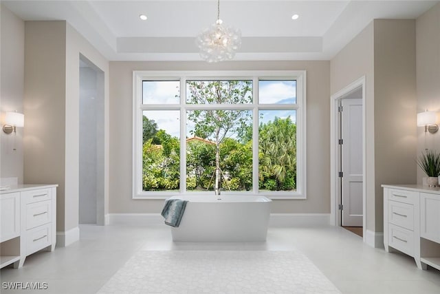 137 Tupelo Rd, Naples, FL 34108 - bathroom with vanity, a freestanding bath, a chandelier, and a tray ceiling