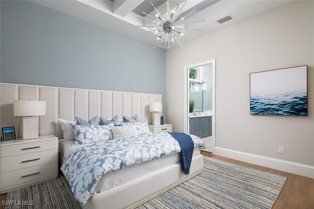 137 Tupelo Rd, Naples, FL 34108 - bedroom with a chandelier, wood finished floors, and ensuite bath