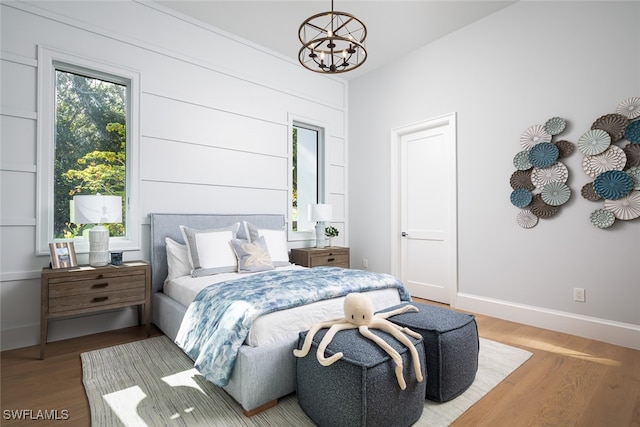 bedroom featuring hardwood / wood-style flooring and an inviting chandelier