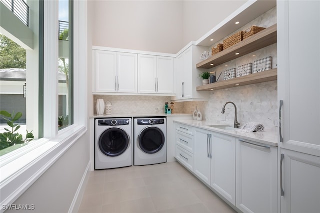 laundry area featuring cabinets, separate washer and dryer, and sink