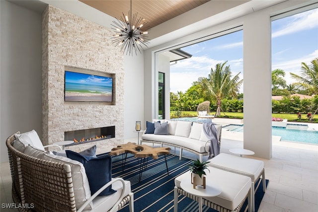 living room with an outdoor stone fireplace, an inviting chandelier, and wooden ceiling