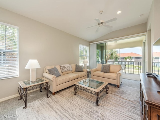 living room featuring ceiling fan, light colored carpet, plenty of natural light, and vaulted ceiling