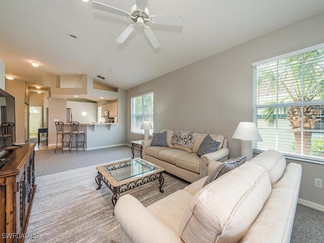 living room with lofted ceiling, carpet flooring, and ceiling fan