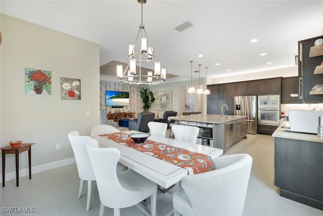 dining room featuring sink, a notable chandelier, and light tile patterned floors