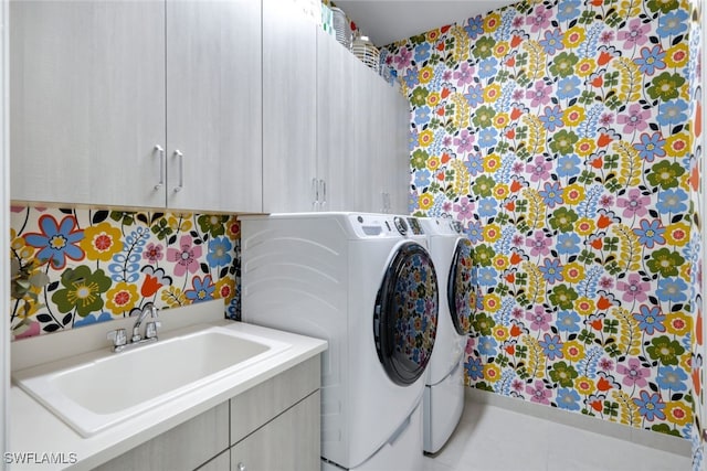 washroom with washing machine and dryer, sink, tile patterned flooring, and cabinets