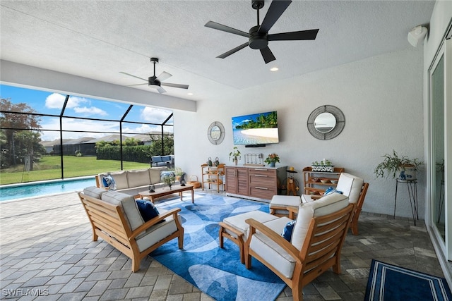 view of patio / terrace featuring a lanai, an outdoor living space, and ceiling fan