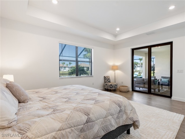 bedroom with hardwood / wood-style floors and access to outside