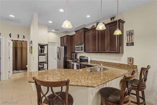 kitchen with stone counters, sink, decorative light fixtures, and stainless steel appliances