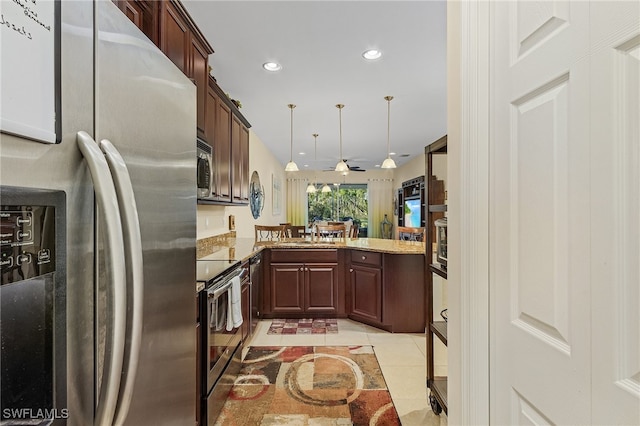 kitchen featuring light stone countertops, appliances with stainless steel finishes, ceiling fan, decorative light fixtures, and light tile patterned floors