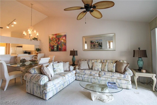 carpeted living room with ceiling fan with notable chandelier and vaulted ceiling