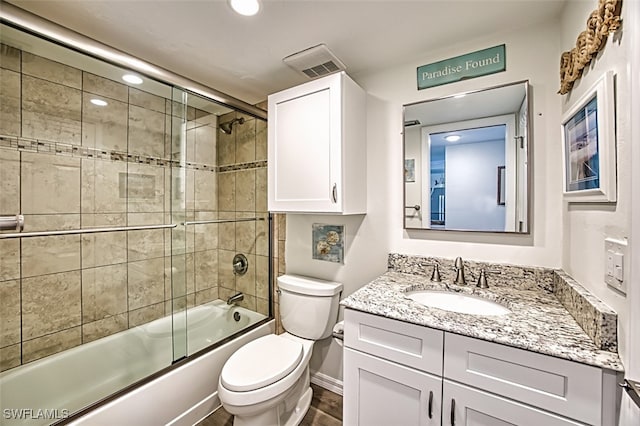 full bathroom with toilet, vanity, and shower / bath combination with glass door