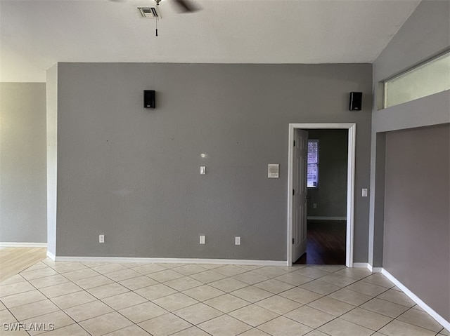 tiled spare room with ceiling fan and vaulted ceiling