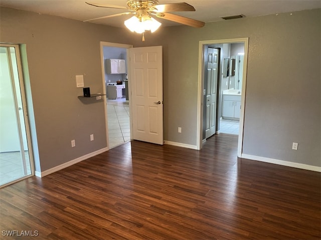 empty room with ceiling fan and dark hardwood / wood-style flooring