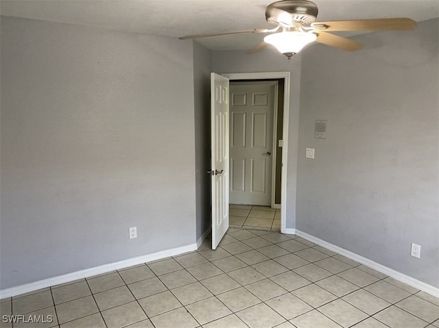 tiled spare room featuring ceiling fan