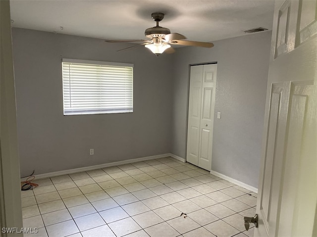 tiled spare room featuring ceiling fan