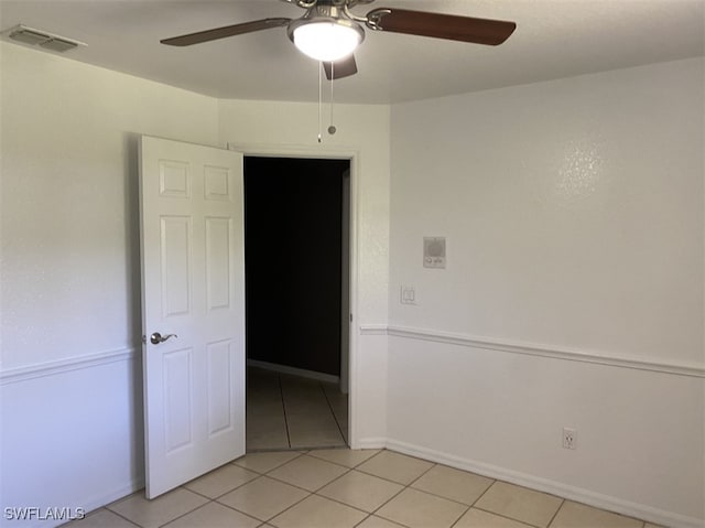 tiled spare room with ceiling fan