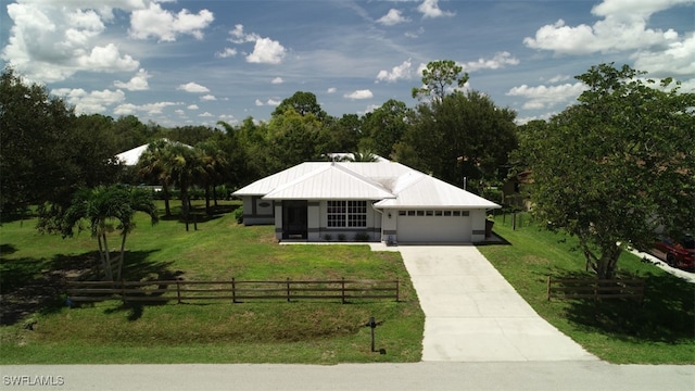 view of front of home featuring a front yard, a rural view, and a garage