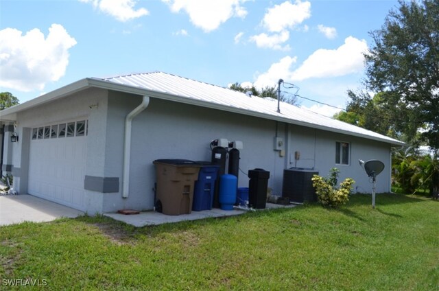 view of property exterior with a yard, a garage, and cooling unit