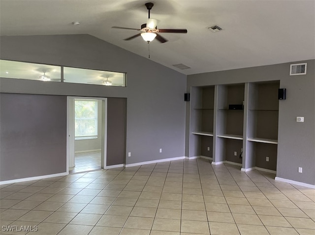 empty room featuring lofted ceiling, built in features, light tile patterned floors, and ceiling fan