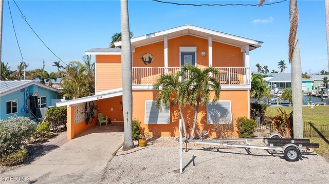 view of front of property featuring a balcony and a carport