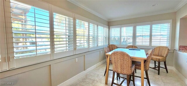 tiled dining room featuring ornamental molding