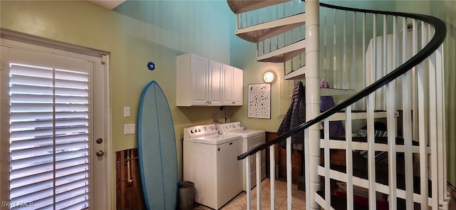 laundry area with separate washer and dryer, light tile patterned floors, and cabinets