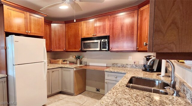 kitchen featuring sink, ceiling fan, light stone countertops, light tile patterned flooring, and white fridge