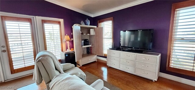 living room featuring crown molding, a healthy amount of sunlight, and dark hardwood / wood-style floors