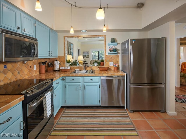 4021 Whiskey Pointe Ln Unit 202, Bonita Springs, FL 34134 - kitchen featuring stainless steel appliances, blue cabinets, tile counters, and tasteful backsplash