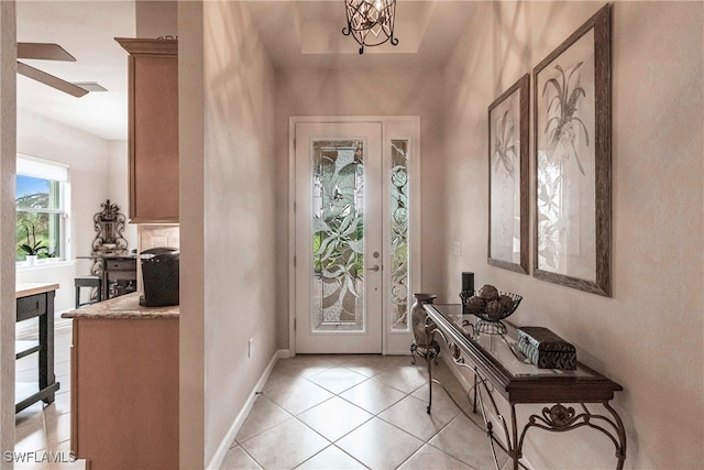 foyer entrance with ceiling fan with notable chandelier and light tile patterned floors