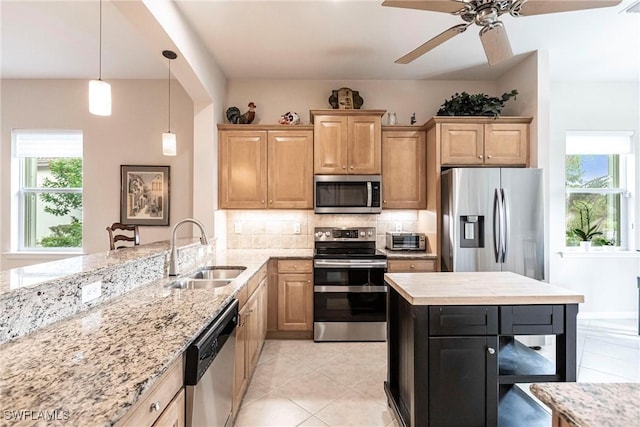 kitchen with ceiling fan, plenty of natural light, tasteful backsplash, a sink, and stainless steel appliances