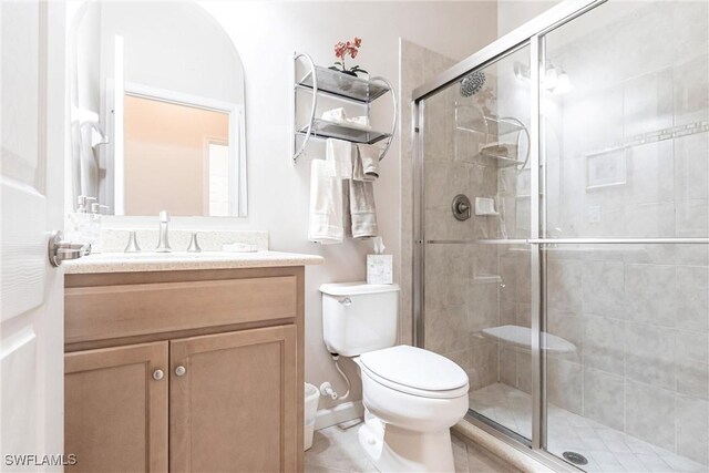 full bathroom with vanity, tile patterned floors, a shower stall, and toilet