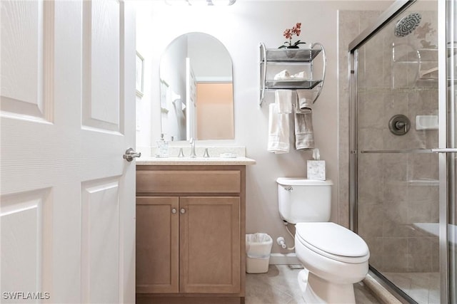 bathroom featuring vanity, tile patterned floors, toilet, and a shower stall