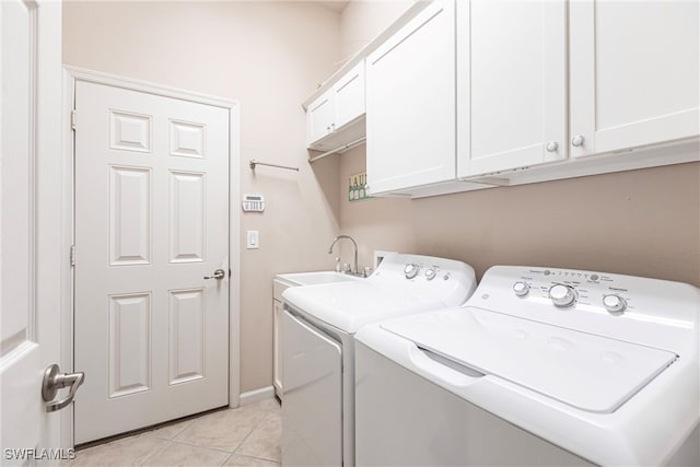 laundry room featuring cabinets, washer and dryer, sink, and light tile patterned floors