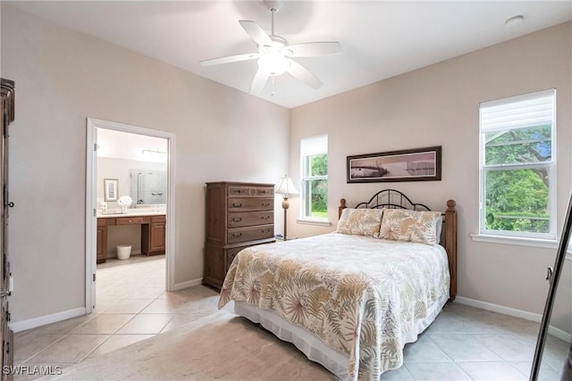 bedroom featuring baseboards, a ceiling fan, ensuite bath, and light tile patterned floors