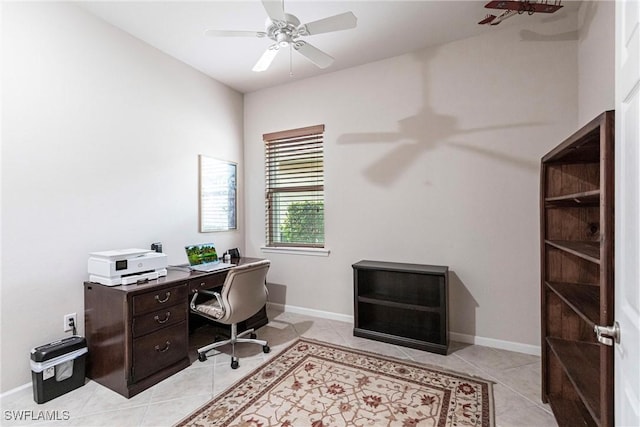 office area with baseboards, a ceiling fan, and light tile patterned flooring