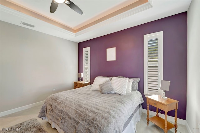 bedroom with a tray ceiling and ceiling fan