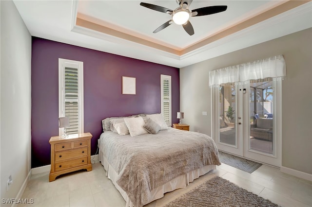 bedroom with ceiling fan, a tray ceiling, light tile patterned floors, and access to exterior