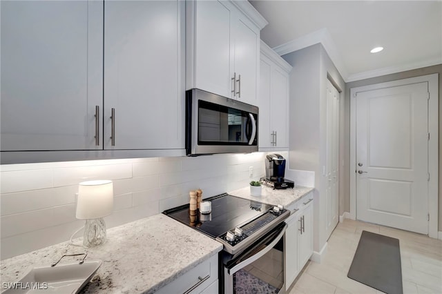 kitchen with light stone counters, appliances with stainless steel finishes, and white cabinets