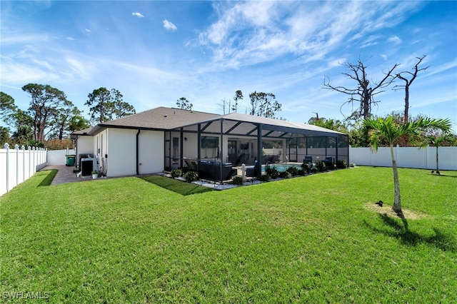 rear view of property featuring a yard, a patio area, a lanai, and a swimming pool