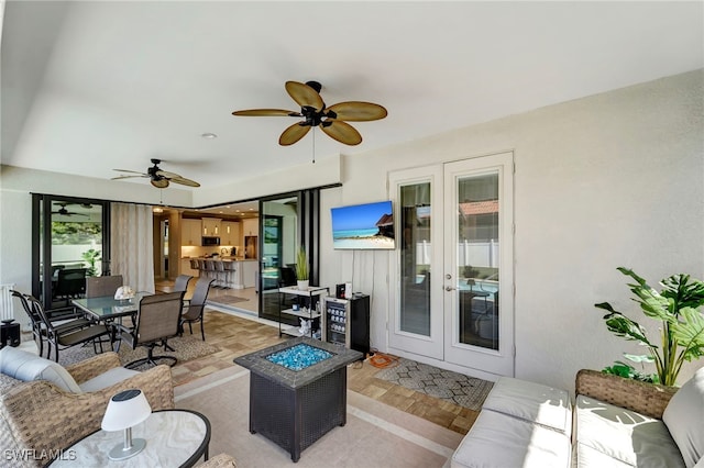 living room with french doors, ceiling fan, and light parquet flooring