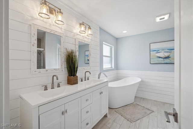 bathroom featuring vanity, independent shower and bath, and wood-type flooring