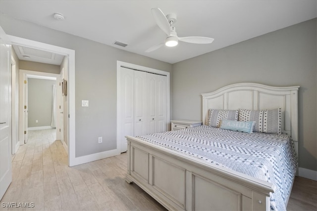 bedroom with a closet, light hardwood / wood-style floors, and ceiling fan