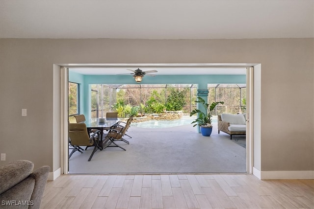 doorway with light hardwood / wood-style floors, plenty of natural light, and ceiling fan