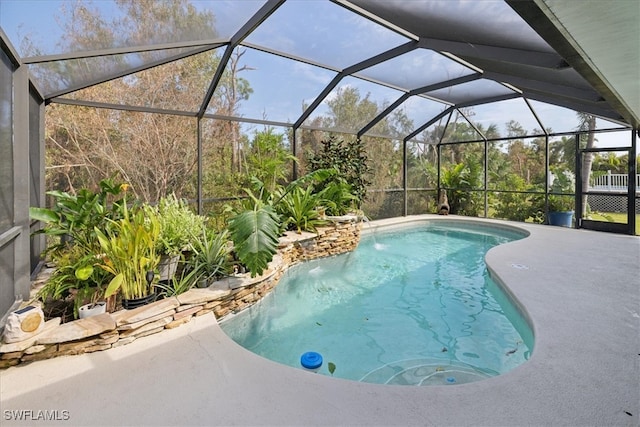 view of pool featuring a patio, pool water feature, and glass enclosure