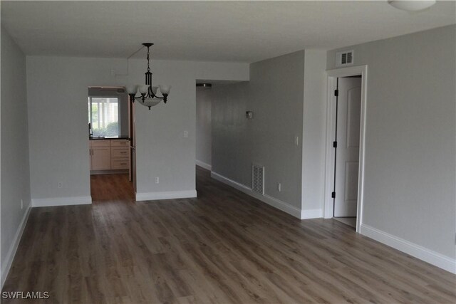 4229 SE 19th Pl Unit 1D, Cape Coral, FL 33904 - empty room with a chandelier, wood finished floors, and baseboards