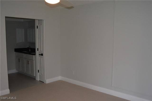 carpeted empty room with sink and ceiling fan