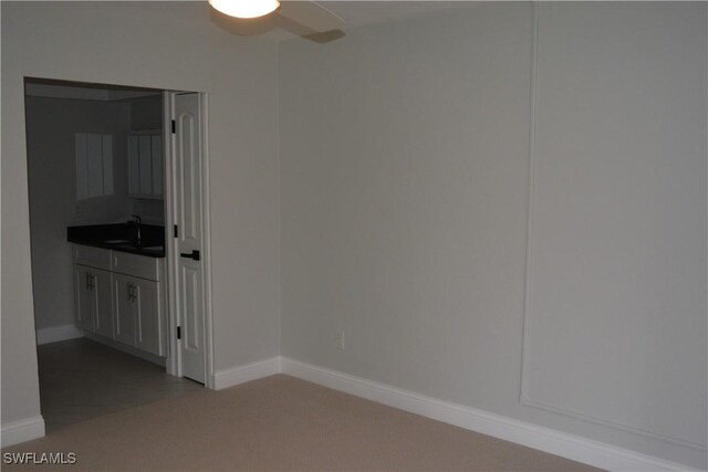 4229 SE 19th Pl Unit 1D, Cape Coral, FL 33904 - empty room featuring a sink, a ceiling fan, light colored carpet, and baseboards