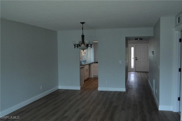 4229 SE 19th Pl Unit 1D, Cape Coral, FL 33904 - unfurnished dining area featuring a chandelier, dark wood finished floors, and baseboards
