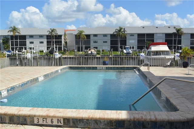 view of swimming pool featuring a patio area and a water view